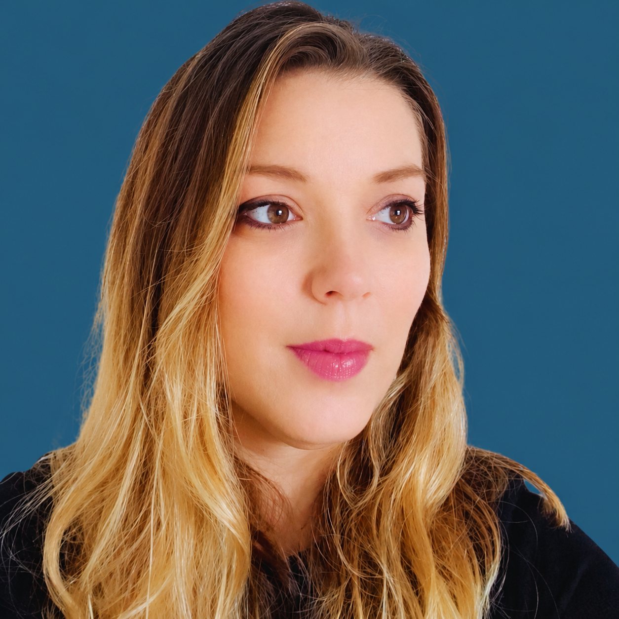 Portrait de Pauline Babeau, directrice pédagogique, devant un fond bleu uni.
